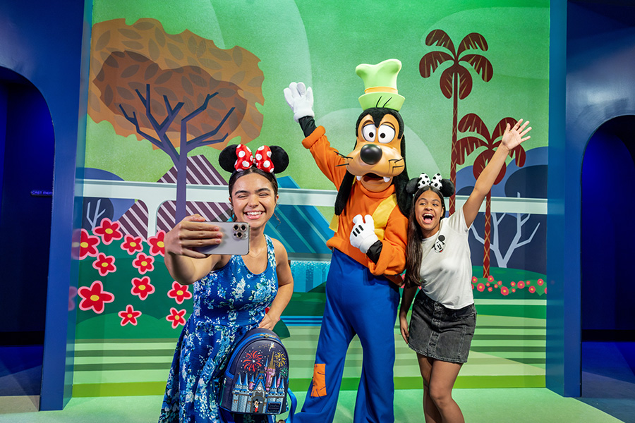 Mickey poses with guests at the new Mickey & Friends character greeting location