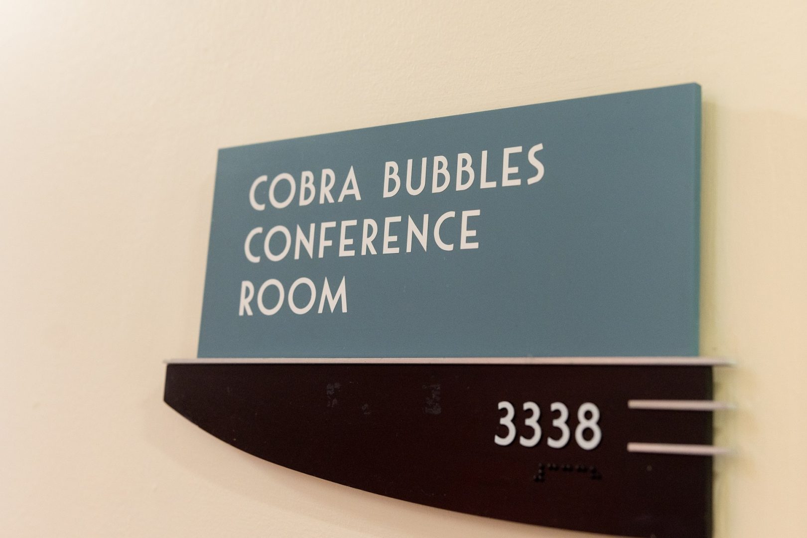 Office and meeting room name plates appear in Art Deco style