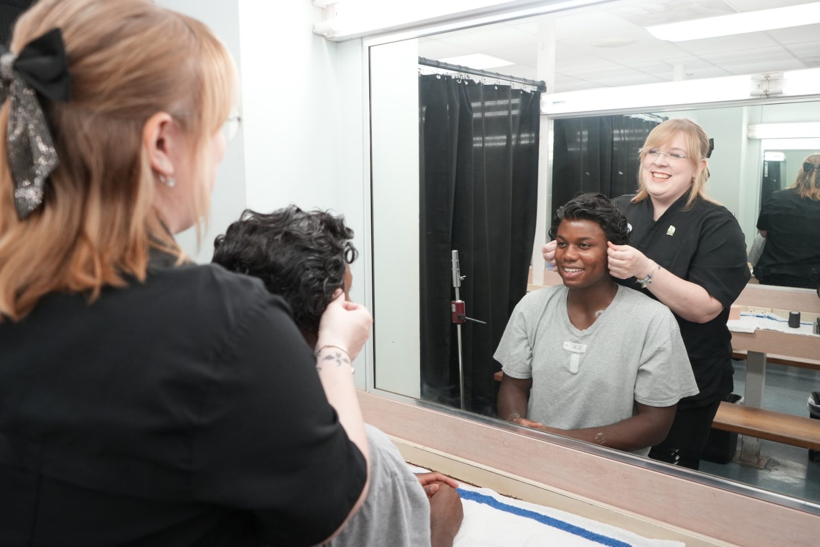 Carli, Cosmetology Trainer prepping wigs in the dressing room