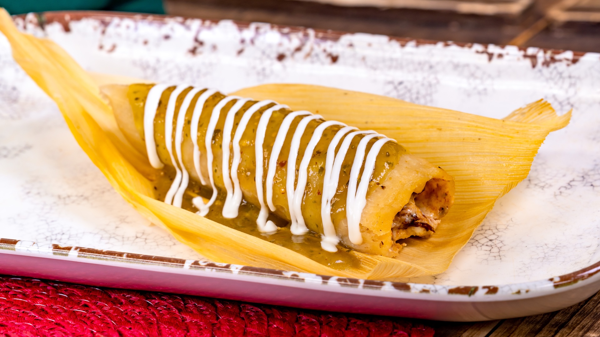 Barbacoa Tamal de Res with Oaxaca cheese, tomatillo salsa, and crema