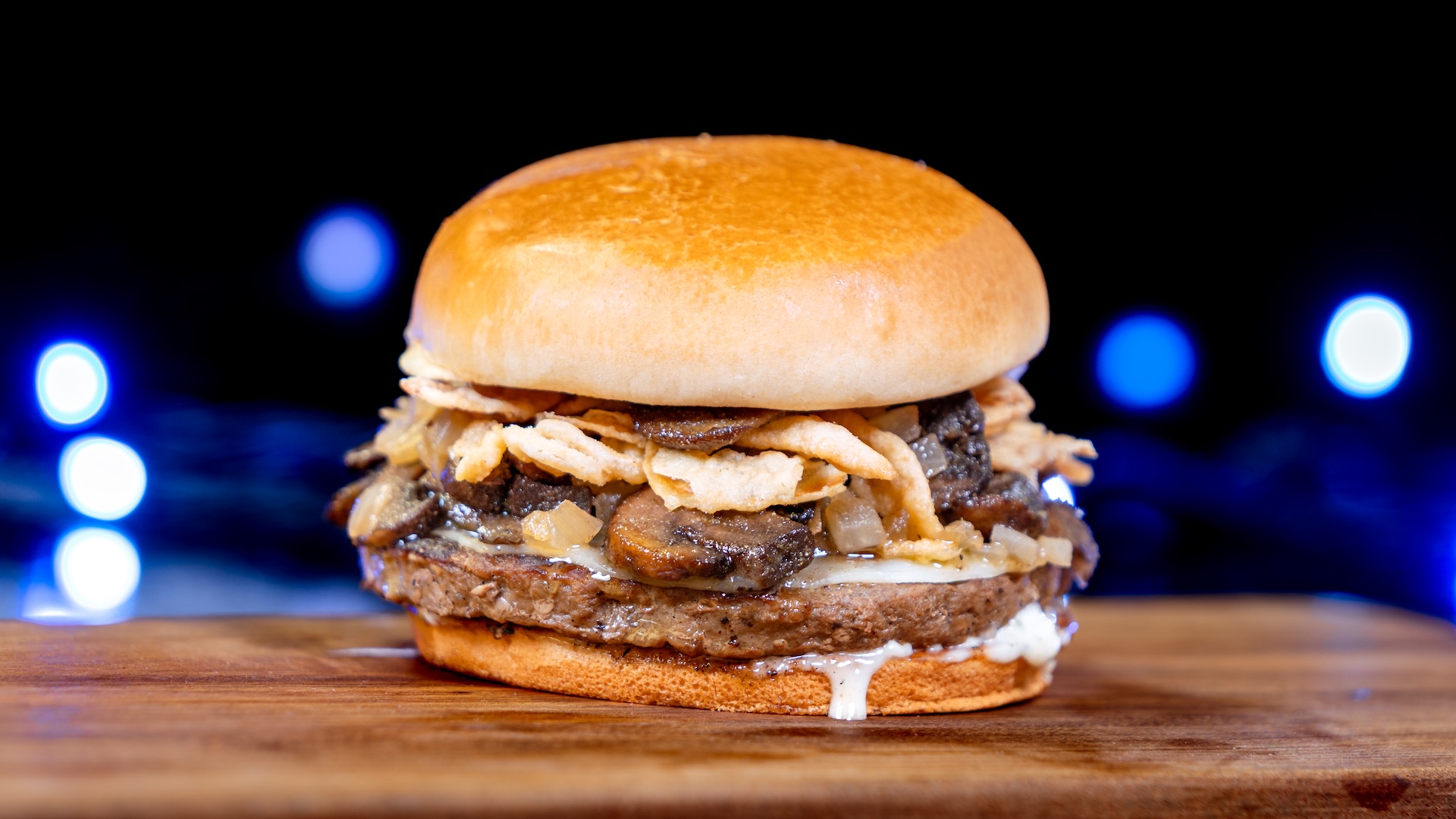 Mushroom and Swiss Burger: Angus beef and vegetable patty, roasted herb mushrooms, caramelized and fried onions, Swiss cheese, and blue cheese sauce served on a toasted brioche bun with your choice of Cuties Mandarin Orange or French fries (New)  