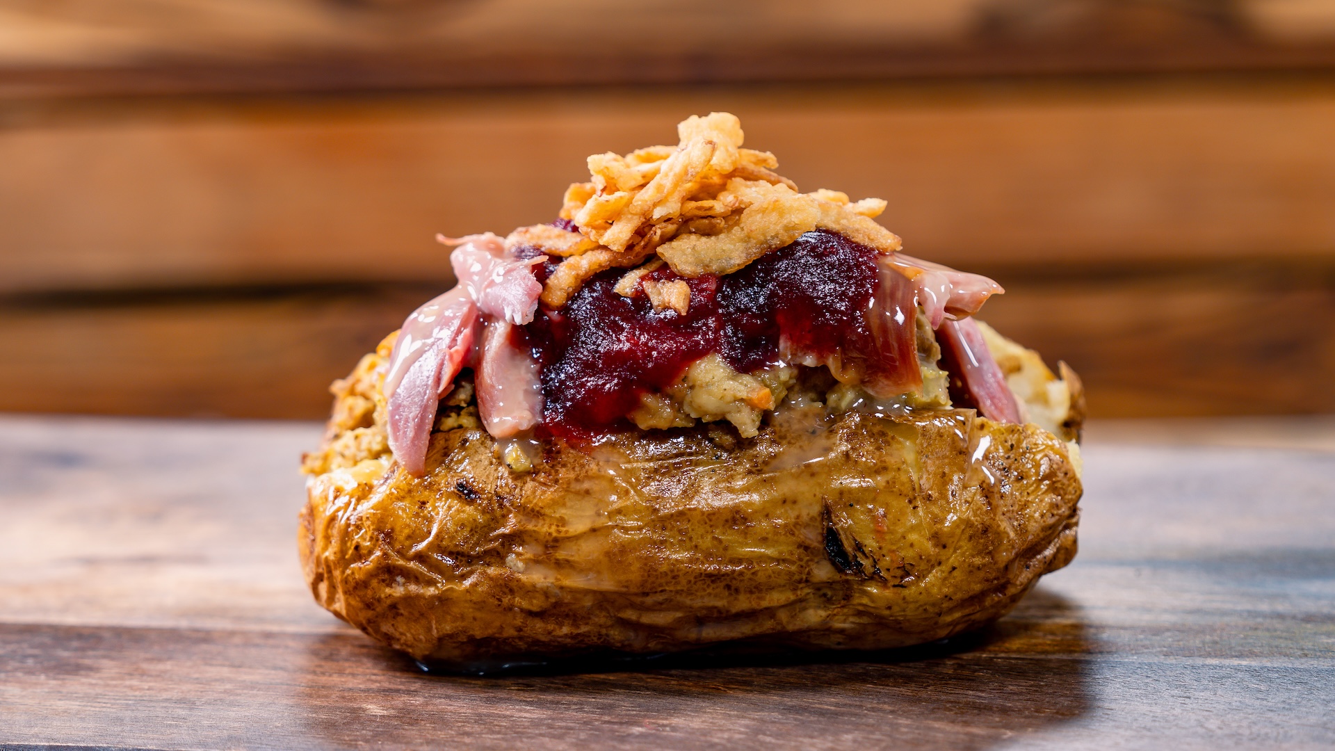Celebration Dinner Potato: Baked potato with pulled smoked turkey, whipped cream cheese, stuffing, cranberry sauce, gravy, and fried onions 