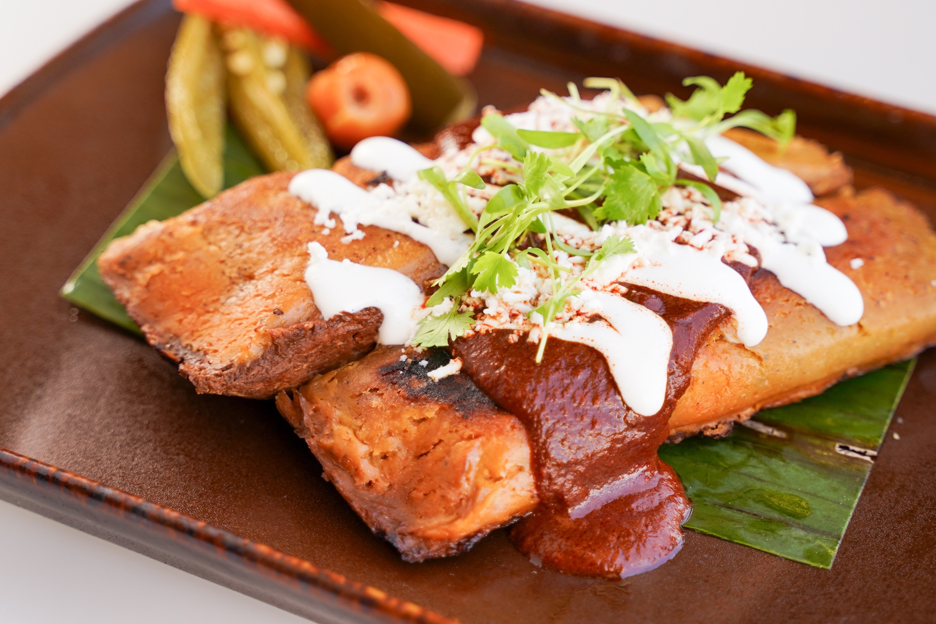 Chicken Tamal: Oaxacan style tamal, with mole rojo, braised chicken, and pickled jalapeños, carrots, and squash veggies (New)  