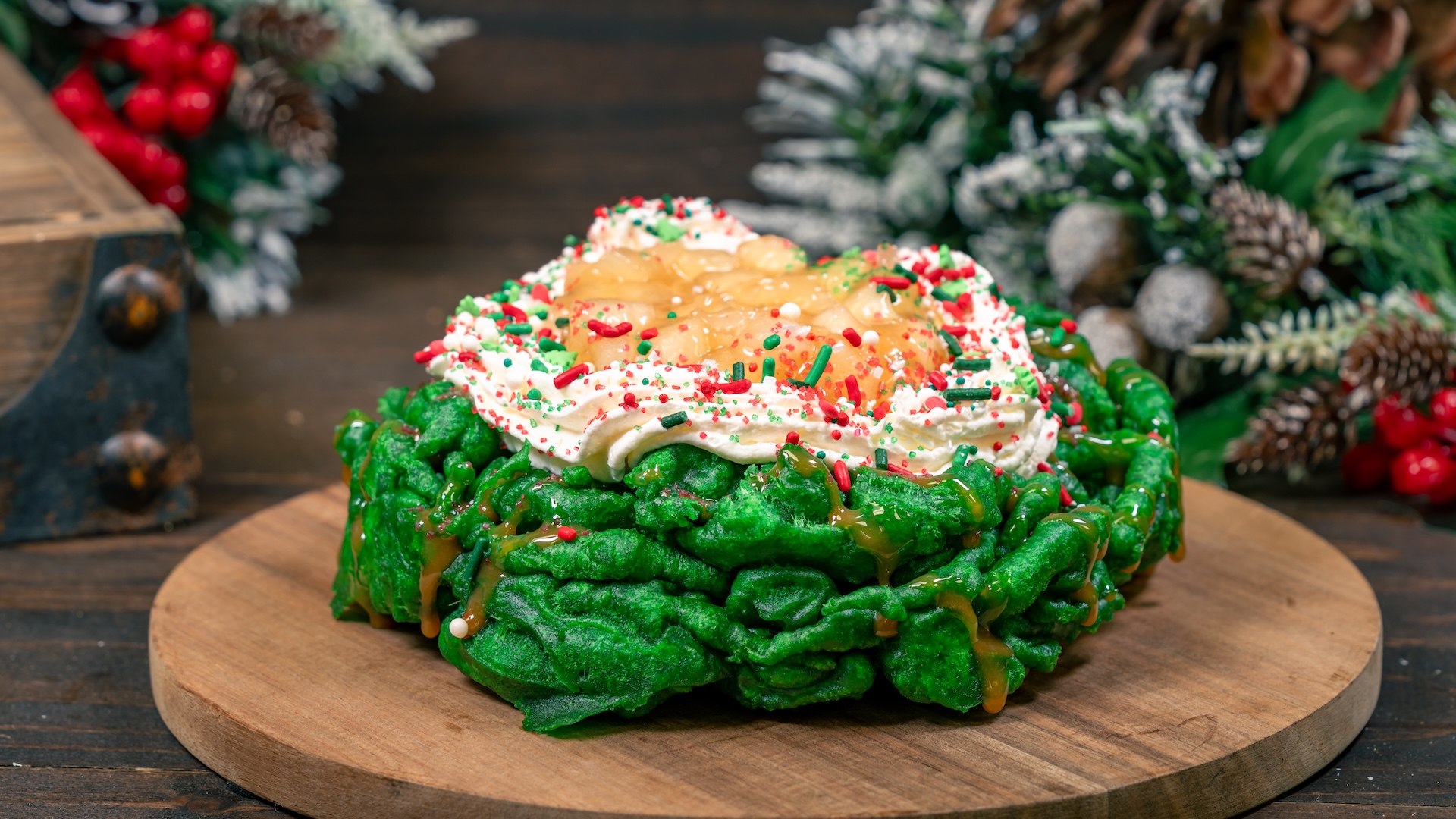 Wreath Funnel Cake: Green funnel cake with caramel sauce, apple filling, whipped topping, and holiday sprinkles 