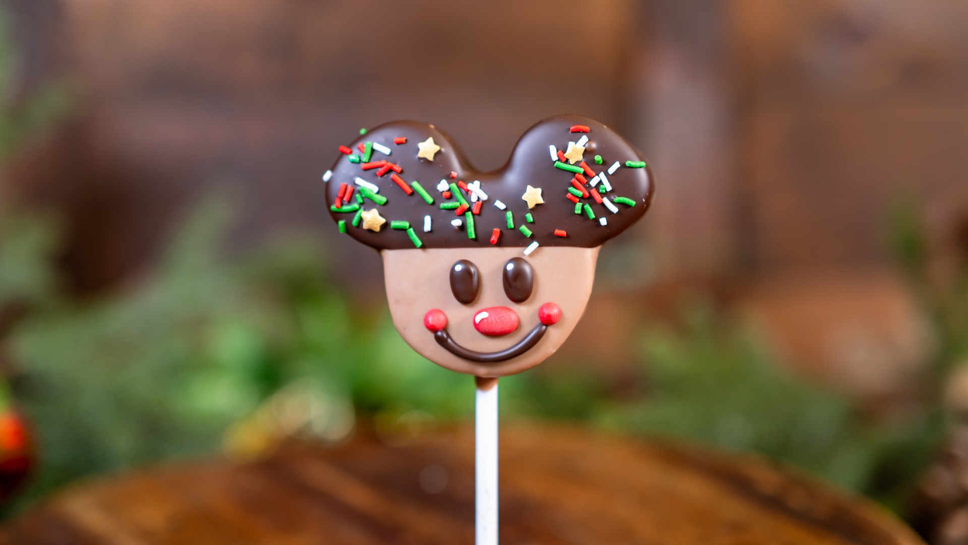Gingerbread Mickey Mallow Pop: Mickey-shaped marshmallow dipped in milk and white chocolate, decorated with dark chocolate, red-colored white chocolate, and embellished with white chocolate and holiday sprinkles (New) 