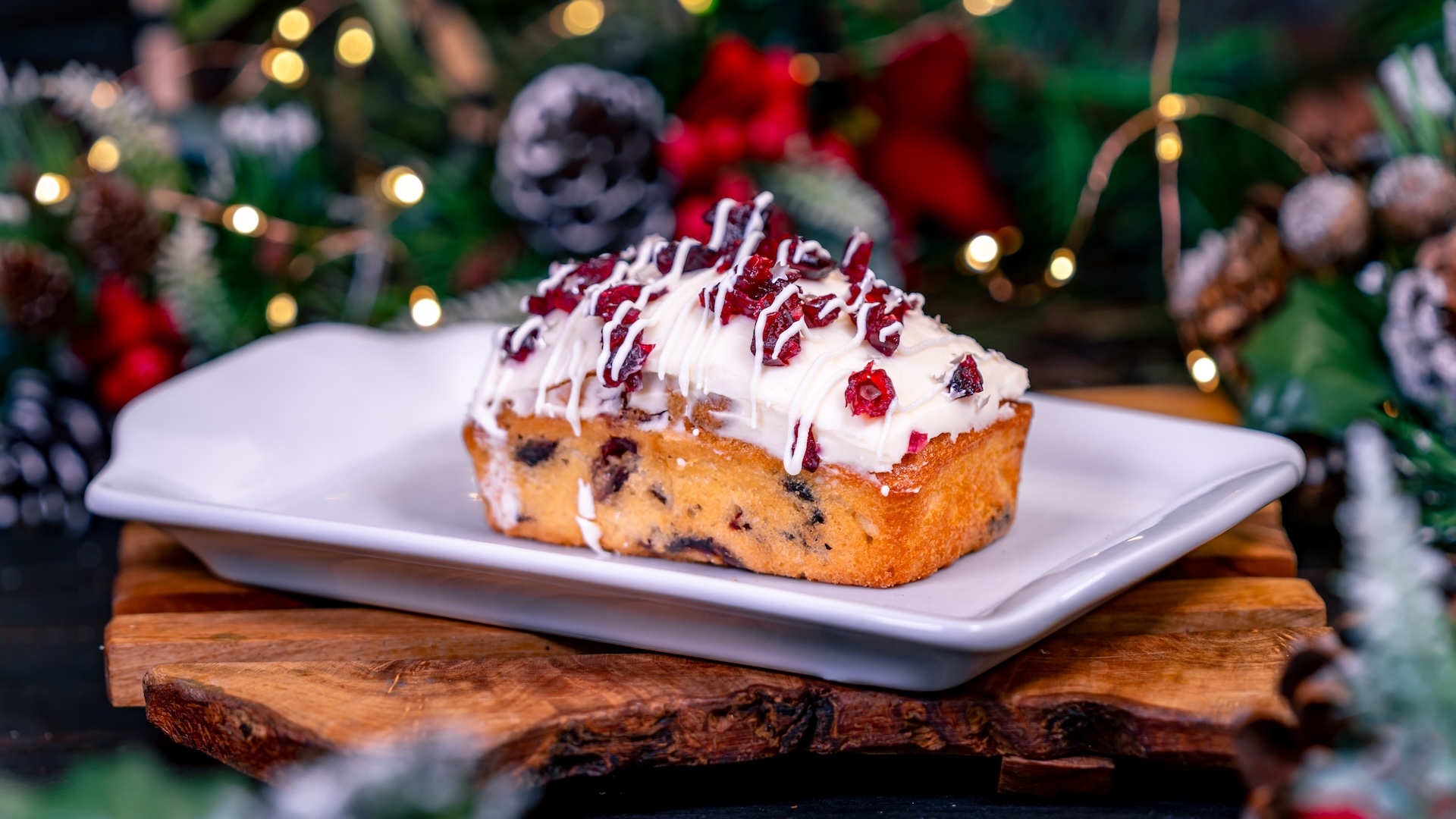 Orange-Cranberry Loaf topped with cream cheese glaze and dried cranberries drizzled with white chocolate 