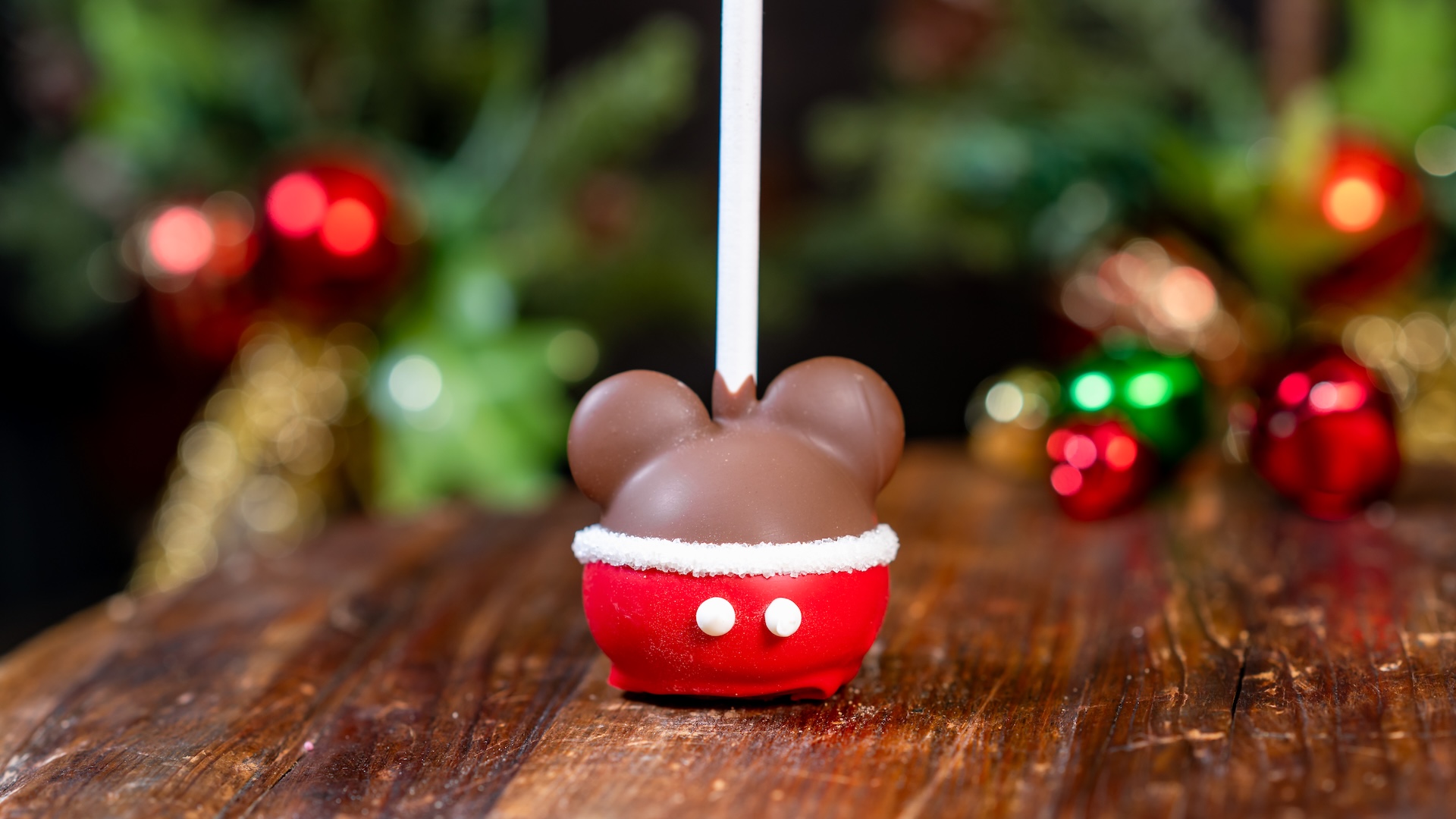 Santa Mickey Cake Pop: Vanilla cake pop with dark chocolate ears and decorated with red-colored white chocolate, white chocolate, and white sanding sugar (Only available at Candy Palace and Candy Kitchen, Pooh Corner, Trolley Treats, and Disney Wonderful World of Sweets) (New) 