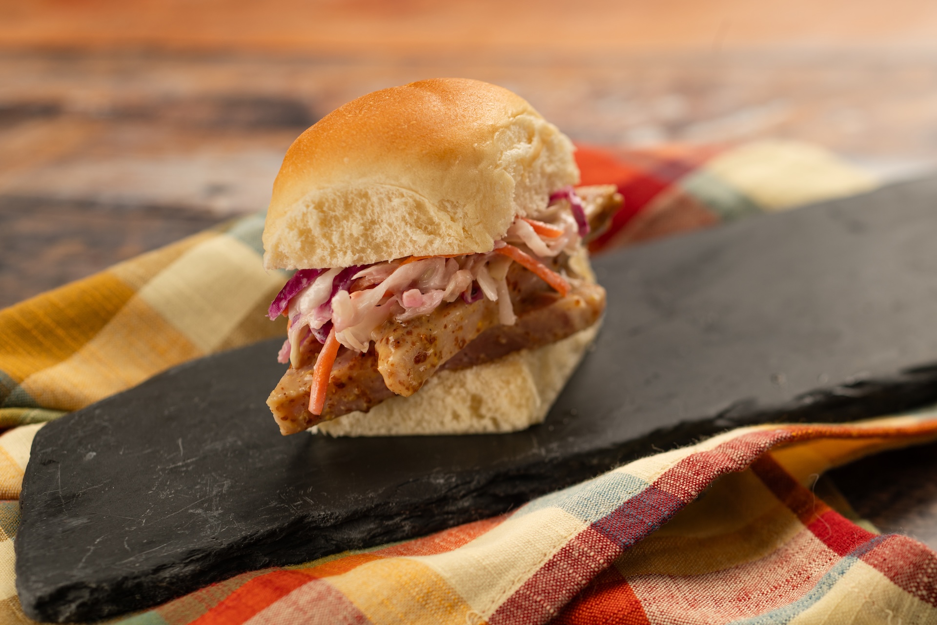 Brown Sugar and Mustard-glazed Ham Sliders with cranberry and apple coleslaw on a Hawaiian roll