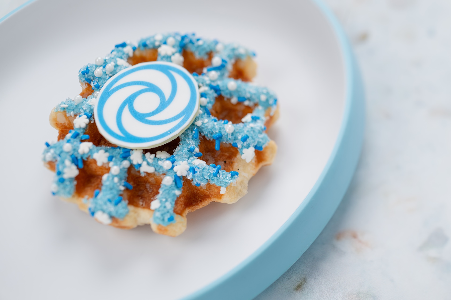 Holiday Sweater Liege Waffle: Chocolate-coated gingerbread waffle with a flurry of blizzard-themed sprinkles and white chocolate garnish