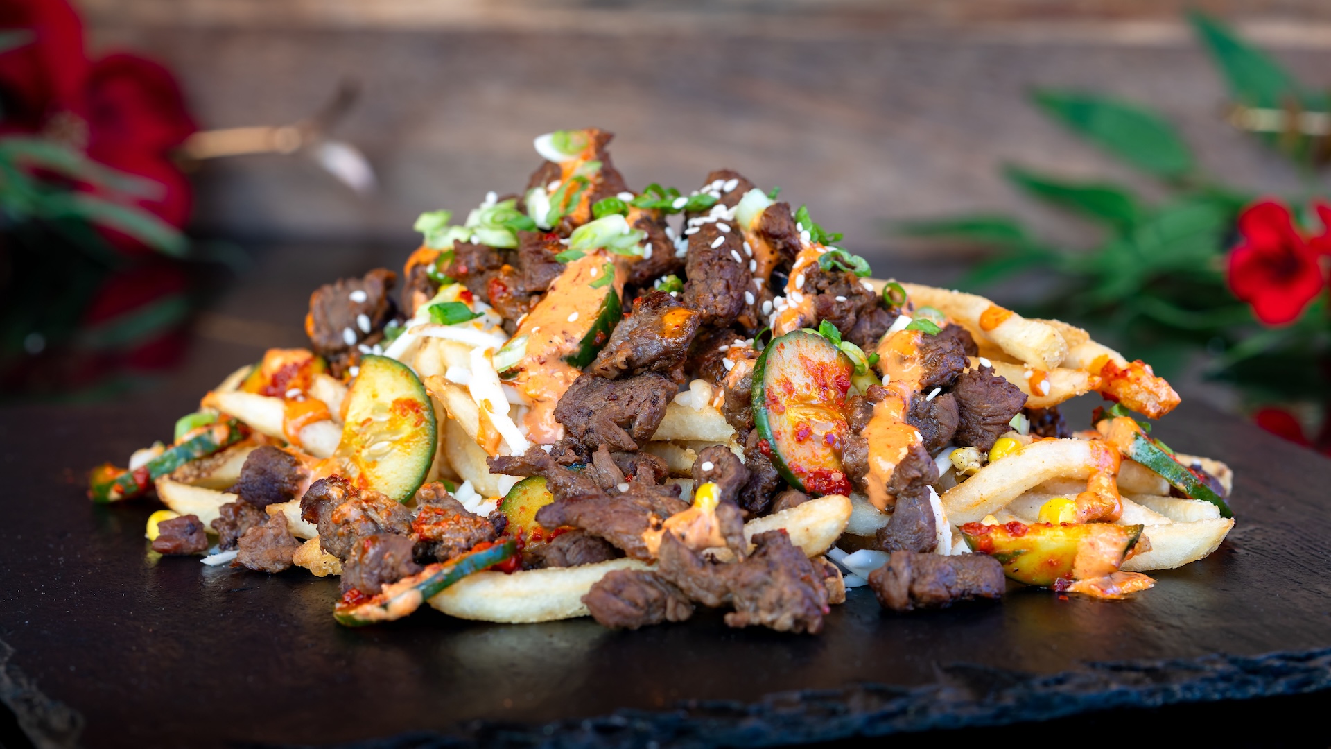 🍽️ Bulgogi Fries: Fries with marinated bulgogi beef, kimchi, cucumber, mozzarella cheese, and gochujang aïoli topped with sesame seeds and green onions (New)