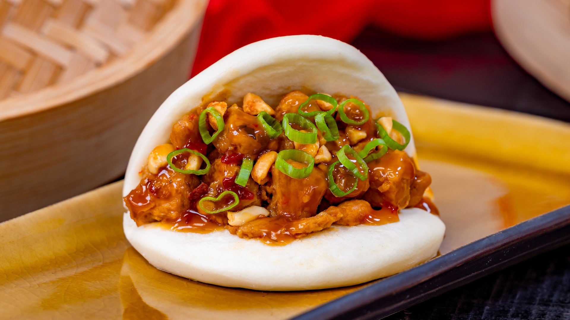 Kung Pao Bao with plant-based chicken, toasted peanuts, and scallions