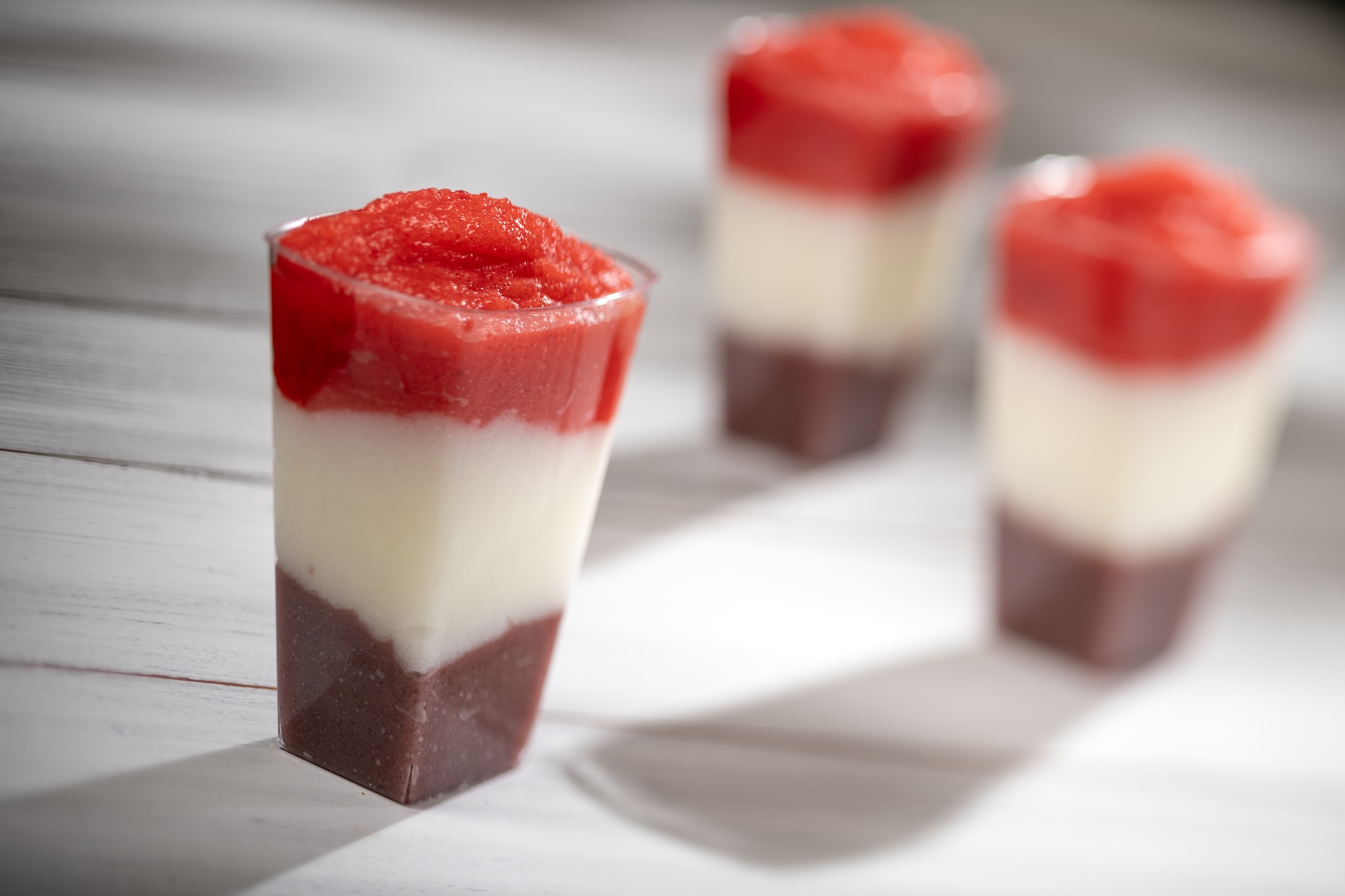 Layered Berry-Piña Colada Smoothie: Wild berry, piña colada, and strawberry with spiced rum