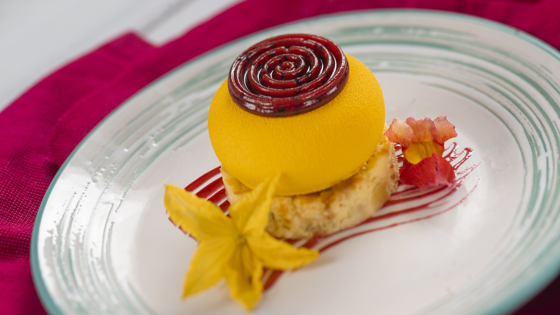 Passion Fruit-filled Mango Cheesecake with coconut-pineapple cake, dragon fruit gelée, and dragon fruit-strawberry sauce
