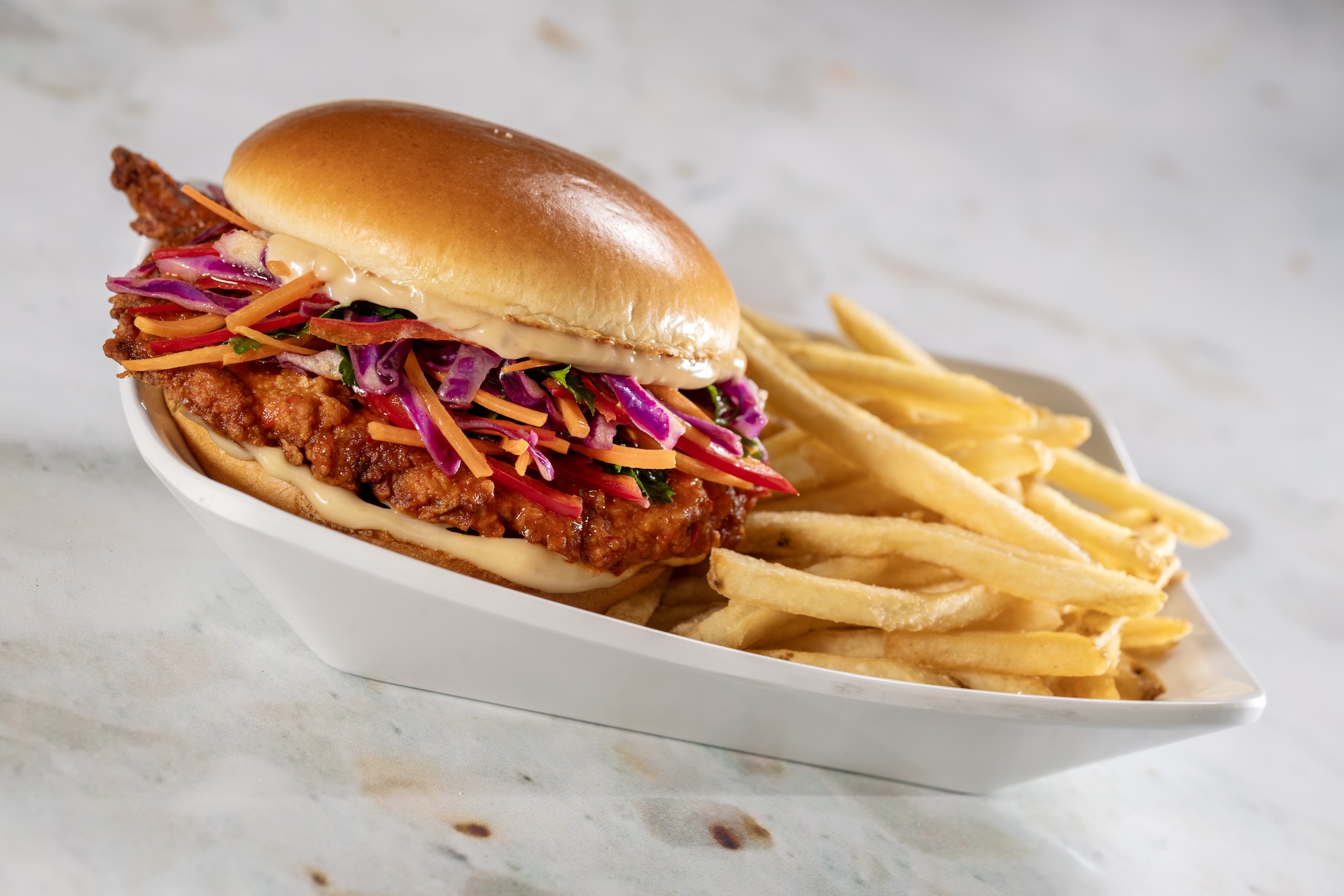 Nashville Hot Chicken Sandwich: Spicy hand-breaded chicken, roasted garlic aïoli, and southern slaw on a toasted brioche bun (New)