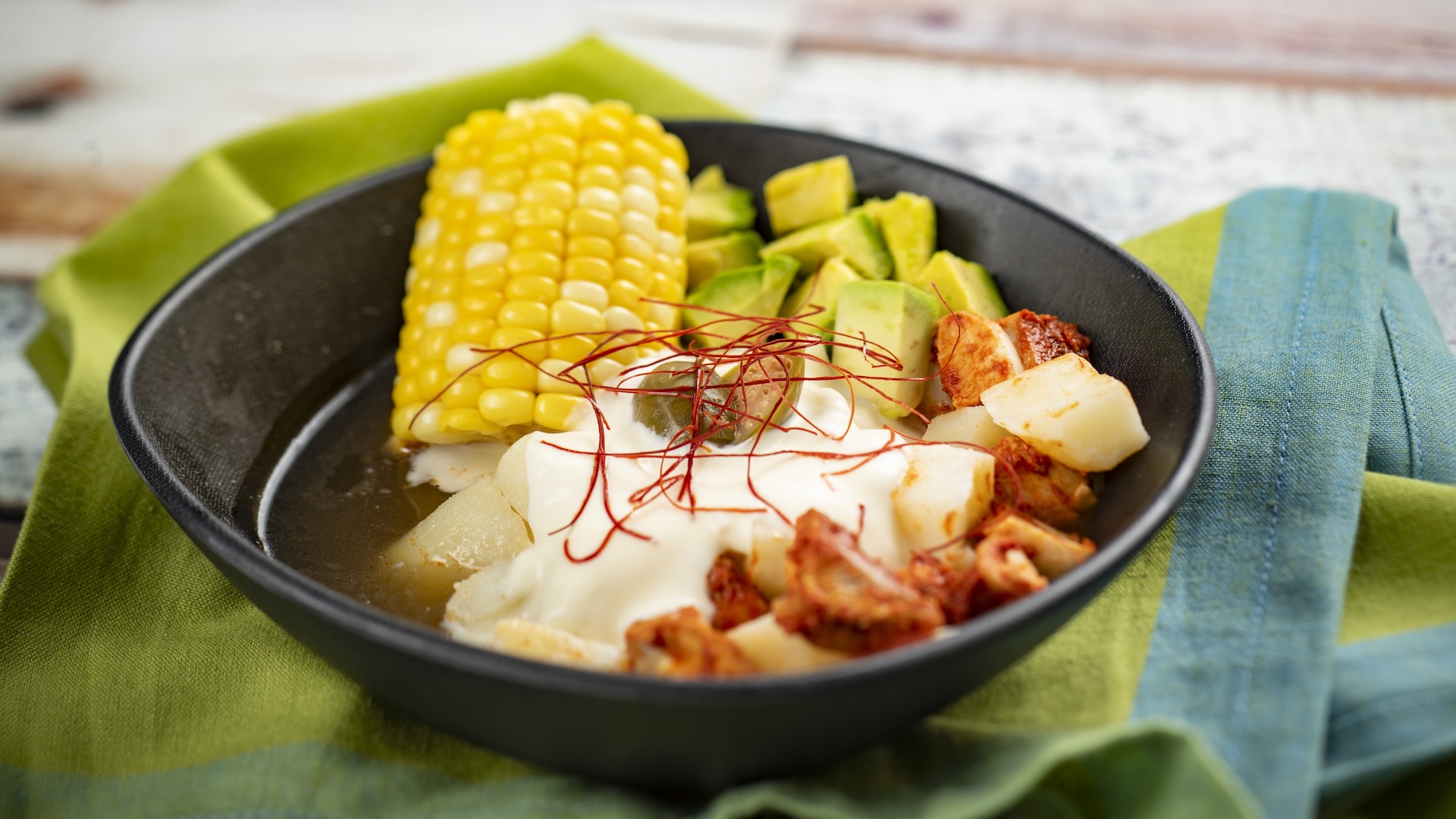 Spicy Ajiaco Soup with guajillo and árbol chili-spiced chicken, potato, avocado, corn, and crème fraîche